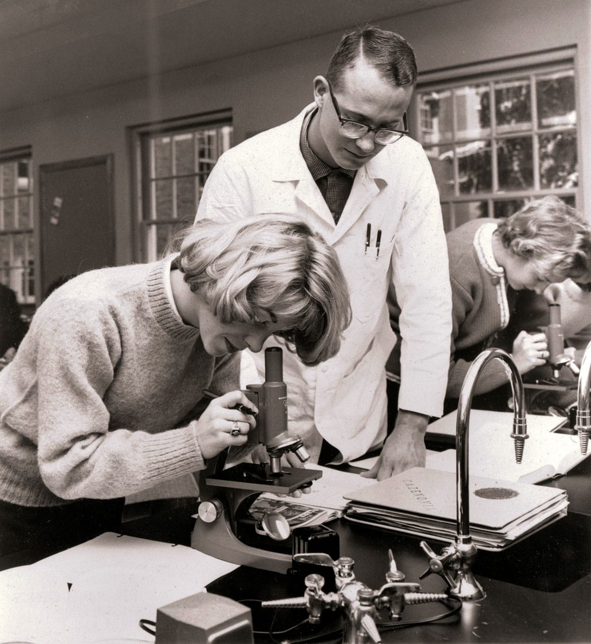 Nursing students looks through microscopes (1963)